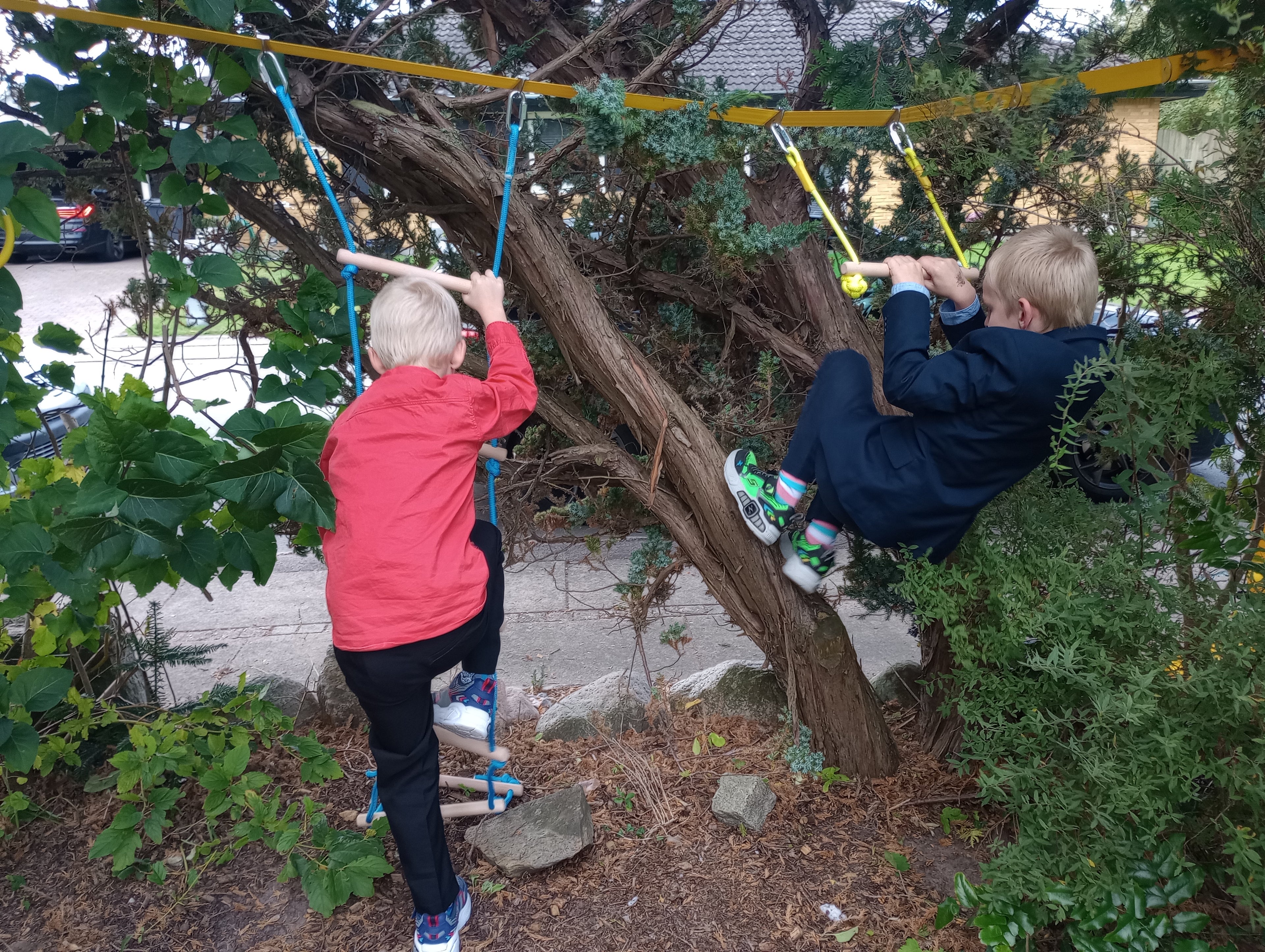 To børn leger og træner motorik på Ninja Kid motorikbane monteret mellem træer.